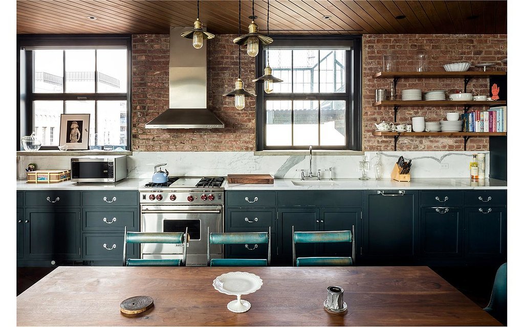 The kitchen's marble countertops add polish to the brick walls, while ...